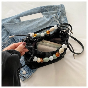 Glossy black pleated bucket bag with colorful resin beads and drawstring closure