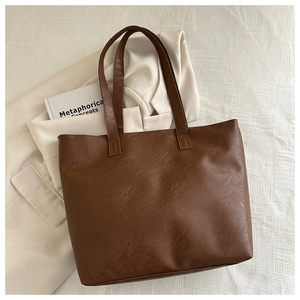 Detailed view of the dark brown lychee textured PU leather on a large tote bag