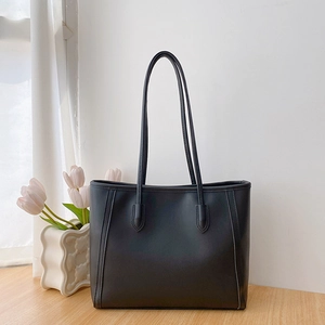 Minimalist black faux leather tote bag with vertical stitching for daily commuting style