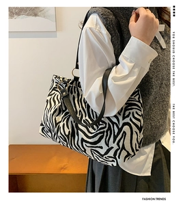 Detail of zebra print canvas tote with black leather strap and gold ring connector