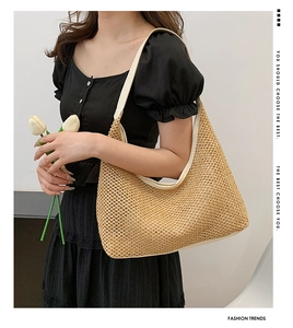 Close-up of woven straw shoulder bag with beige leather trim and large capacity design