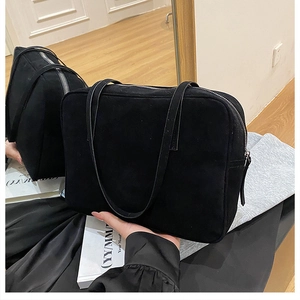 Detailed view of the large black suede shoulder bag with silver zipper and dual handles