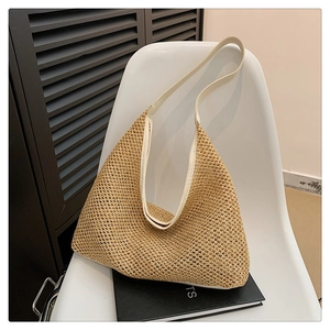 Detail of the woven mesh texture and creamy white leather strap on this beach tote bag