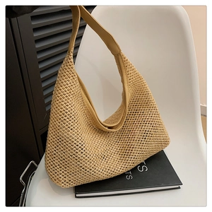 Detail showing the woven fiber texture and reinforced leather straps of the khaki hobo bag