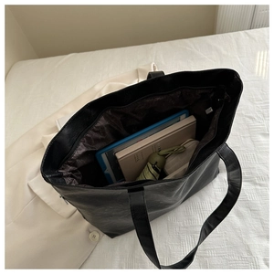 Top view of spacious black tote bag showing organized interior storage for daily items