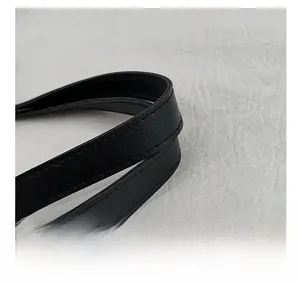 Close-up of black leather strap with precise stitching on a leopard print tote bag