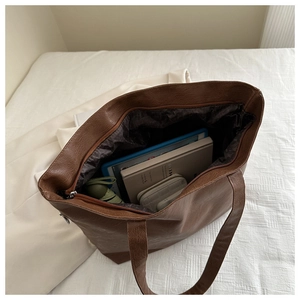 Large brown tote bag showing spacious interior with tablet, notebook, and folding umbrella