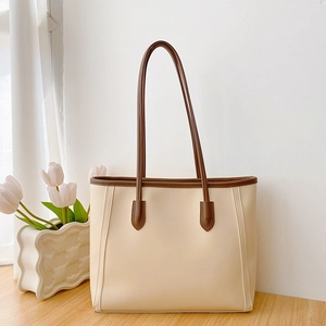 Fashionable large capacity tote bag in cream white with dark brown trim and handles