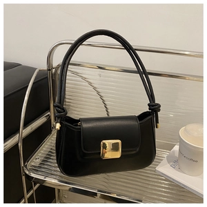 Close-up of black leather shoulder bag featuring a gold square buckle and knot detail