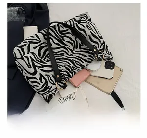 Detail of zebra print canvas tote bag showing interior space with tablet and phone
