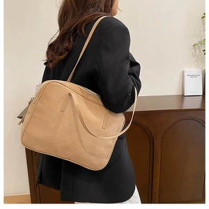 Detailed side view of khaki large capacity commuter tote bag on a model shoulder