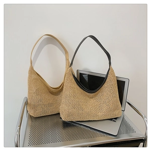 Detail of woven straw hobo bags with leather straps on a modern metallic cart