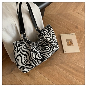 Detail of zebra print canvas tote with leather strap and golden ring connector