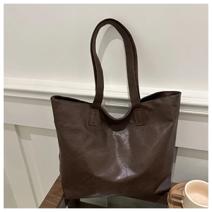 Close-up of fine stitching and rich leather texture on dark brown large tote bag