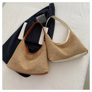 Detail of woven straw hobo bag with premium leather trim and textured knit design