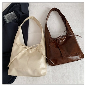 Close-up of minimalist hobo bags with decorative bow details and spacious capacity