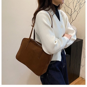 Detailed side view of deep brown suede shoulder bag with high-capacity rectangular design