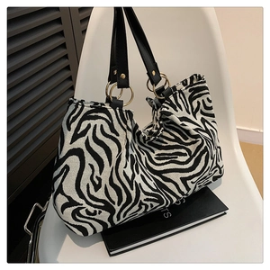 Detail of zebra pattern tote bag with leather handles and gold ring connectors