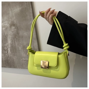 Detail of neon green leather handbag featuring golden square buckle and knotted strap