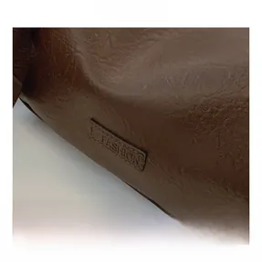 Close-up of brown textured leather Boston bag featuring a stitched Fashion label detail