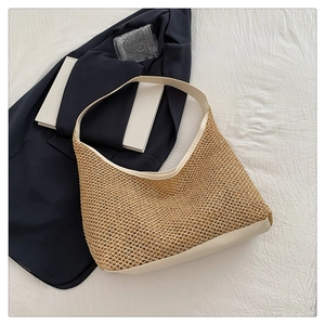 Top view of woven straw tote bag with creamy white leather trim and straps