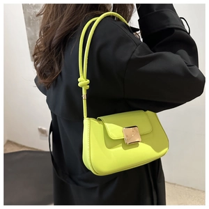 Close-up of fluorescent yellow patent leather bag with a large gold square metal buckle