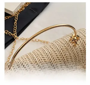 Détail du sac en paille moderne avec poignée ronde en métal doré et fine bandoulière