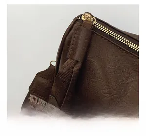 Detail of brown vintage leather Boston bag with gold zipper and geometric strap