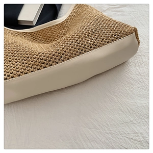 Macro detail of hand-woven straw tote with premium white leather stitching and texture