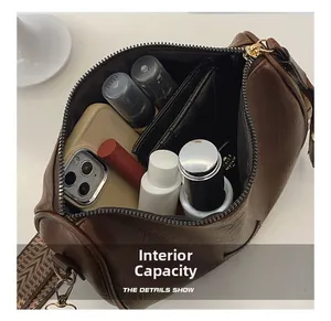 Macro view of brown leather Boston bag showing spacious internal capacity and storage