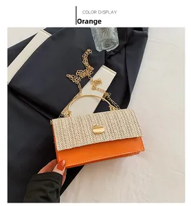 Détail du sac bandoulière en paille tressée et cuir orange avec chaîne dorée