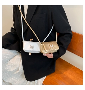 Detail of mini crossbody bags with butterfly metal buckle in white and gold leather finishes