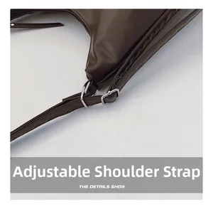 Close-up of adjustable shoulder strap with silver buckle on a brown leather tote bag