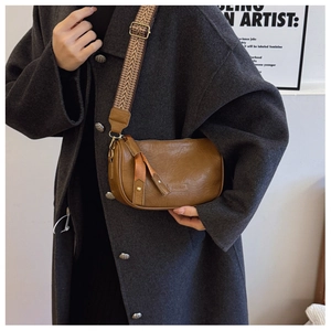 Brown retro pillow bag featuring a wide woven strap and crinkle leather texture detail
