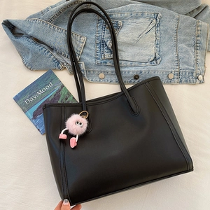 Minimalist large black faux leather tote bag with a pink plush monster charm