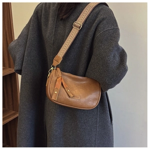 Detailed texture of brown pebble leather bag with vintage woven shoulder strap