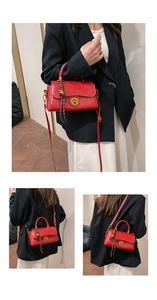 Detail view of a retro red leather crossbody bag with golden clasp and adjustable strap