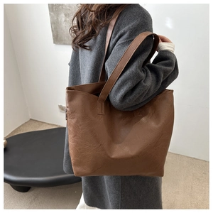 Close-up of brown pebbled leather tote bag showing high-quality texture and shoulder strap