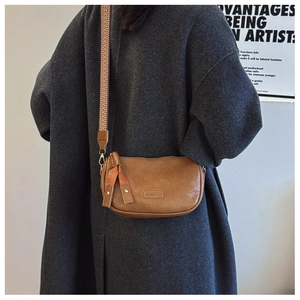 Detail of brown Boston bag with ethnic geometric strap and vintage PU texture