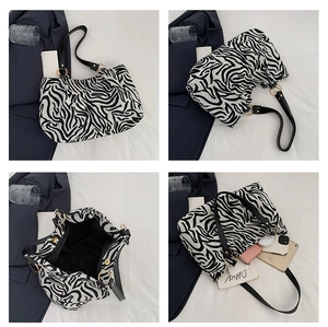 Macro shot of large zebra print tote bag featuring black shoulder strap and magnetic closure