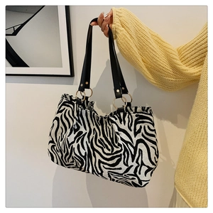 Detail of zebra pattern canvas tote bag with leather handles and metal rings