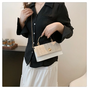 Détail du rabat en paille et sac en cuir blanc avec chaîne dorée et poignée en métal