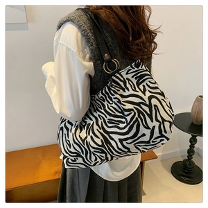 Detailed view of stylish zebra print canvas tote with black strap and gold metal rings