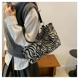 Large capacity zebra print shoulder bag shown with black leather strap and metal rings
