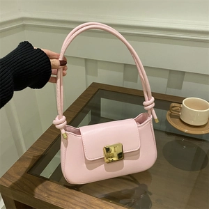 Pink faux leather shoulder bag with gold square buckle and decorative knotted handle