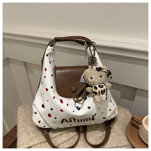 Dettaglio della borsa tote a pois colorati con un simpatico portachiavi a gattino