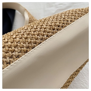 Detail of woven straw tote bag with cream leather stitching and refined craftsmanship