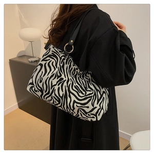 Zebra print tote bag with black strap and gold metal rings shown on a model