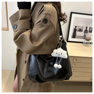 Dettaglio della borsa hobo nera in pelle PU liscia con ciondolo a nuvola bianca soffice