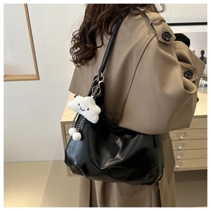 Dettaglio della borsa tote in ecopelle nera con un simpatico ciondolo a nuvola bianca